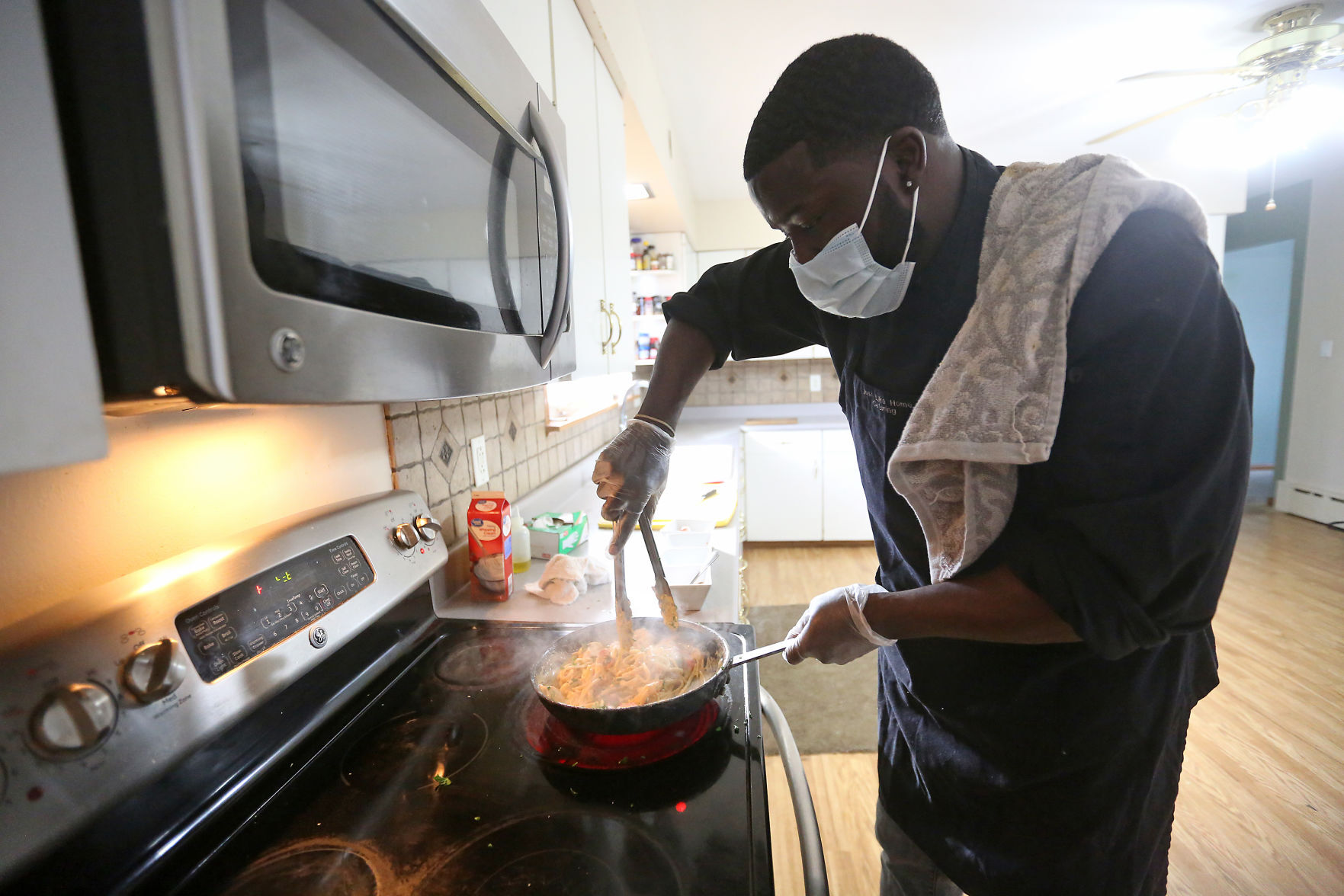 Ty Beard, with Just Like Home Catering, makes cajun seafood pasta at his home in Asbury, Iowa, on Monday. PHOTO CREDIT: JESSICA REILLY