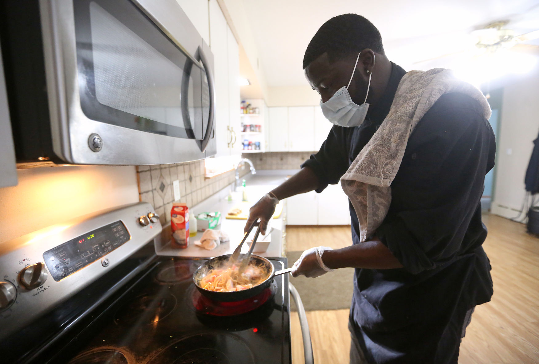 Ty Beard, with Just Like Home Catering, makes cajun seafood pasta at his home in Asbury, Iowa, on Monday. PHOTO CREDIT: JESSICA REILLY