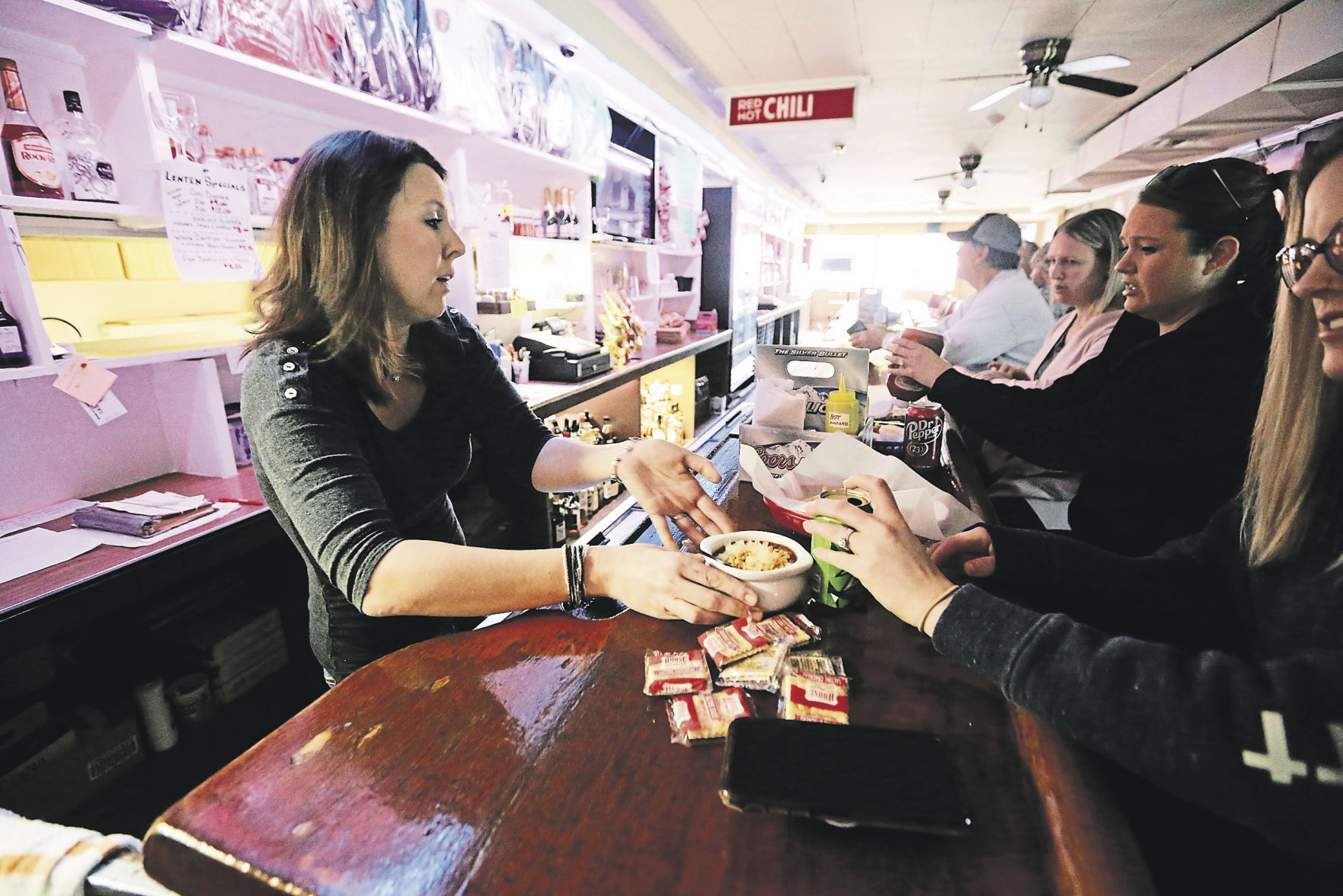 Terissa Ohnesorge (left) serves customers at Mulgrew’s Tavern, Slots & Liquor Store in East Dubuque, Ill. PHOTO CREDIT: NICKI KOHL