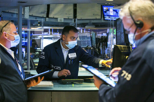 In this photo provided by the New York Stock Exchange, specialist Dilip Patel, center, works with traders on the floor, Monday, March 1, 2021. Stocks are rising across the board on Wall Street as traders welcomed a move lower in long-term interest rates in the bond market. Investors were also watching Washington as a big economic stimulus bill moved to the Senate. (Courtney Crow/New York Stock Exchange via AP) PHOTO CREDIT: Courtney Crow