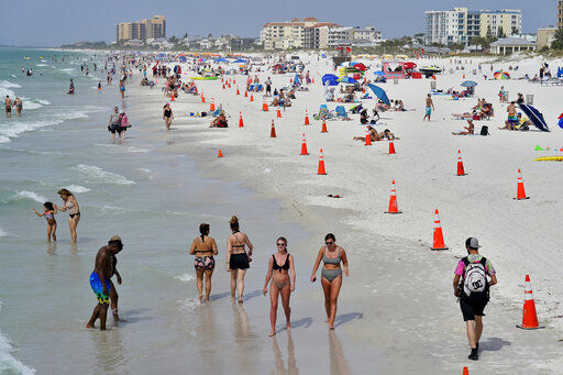 Beachgoers take advantage of the weather as they spend time on Clearwater Beach in Clearwater, Fla., a popular spring break destination. Colleges around the U.S. are scaling back spring break or canceling it entirely to discourage beachfront partying that could raise infection rates back on campus. PHOTO CREDIT: Chris O