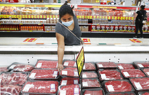 FILE - In this April 29, 2020 file photo, amid concerns of the spread of COVID-19, a shopper wears a mask as she looks over meat products at a grocery store in Dallas. The rise in wholesale prices moderated a bit in February after a record increase in January with both months being hit with higher energy prices. The Labor Department reported Friday, March 12, 2021, that its producer price index, which measures inflation before it reaches consumers. increased by 0.5% last month following a record jump of 1.3% in January. (AP Photo/LM Otero, File) PHOTO CREDIT: LM Otero