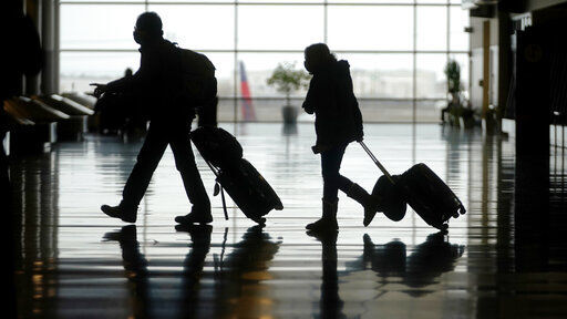 FILE - In this Tuesday, March 9, 2021 file photo, travelers walk through the Salt Lake City International Airport, in Salt Lake City. The number of people flying in the United States has eclipsed the year-ago level for the first time in the pandemic period, although travel remains deeply depressed from 2019. The Transportation Security Administration said 1.34 million people passed through U.S. airport checkpoints on Sunday, March 14 topping the 1.26 million people that TSA screened on the comparable Sunday a year ago. (AP Photo/Rick Bowmer, File) PHOTO CREDIT: Rick Bowmer