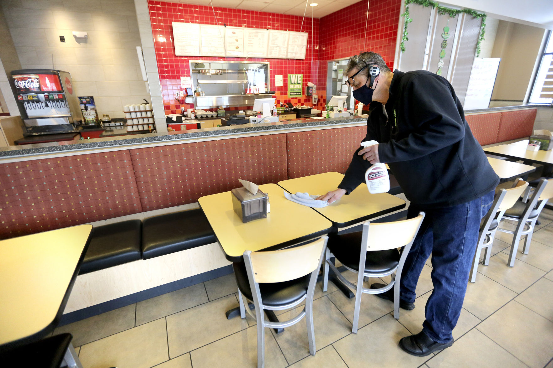 Ozzy Ramadani, the owner of Papa Ozz, 3340 John F. Kennedy Road in Dubuque, cleans tables there Monday. The business opened in August, and many of its employees and menu items have migrated from the recently closed Point Cafe. PHOTO CREDIT: Dave Kettering