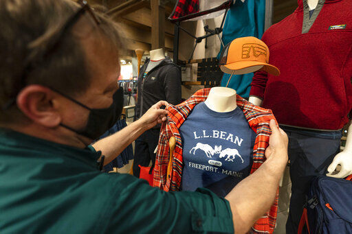 Will Foster, a worker at the L.L. Bean flagship retail store, adjusts display clothing on a mannequin, Thursday, March 18, 2021, in Freeport, Maine. Maine-based retailer L.L. Bean saw the best sales in nearly a decade during pandemic. Officials say the Freeport-based retailer started its fiscal year with store closings and worries about survival but the company weathered the turbulent times to revenue growth of 5%. (AP Photo/Robert F. Bukaty) PHOTO CREDIT: Robert F. Bukaty