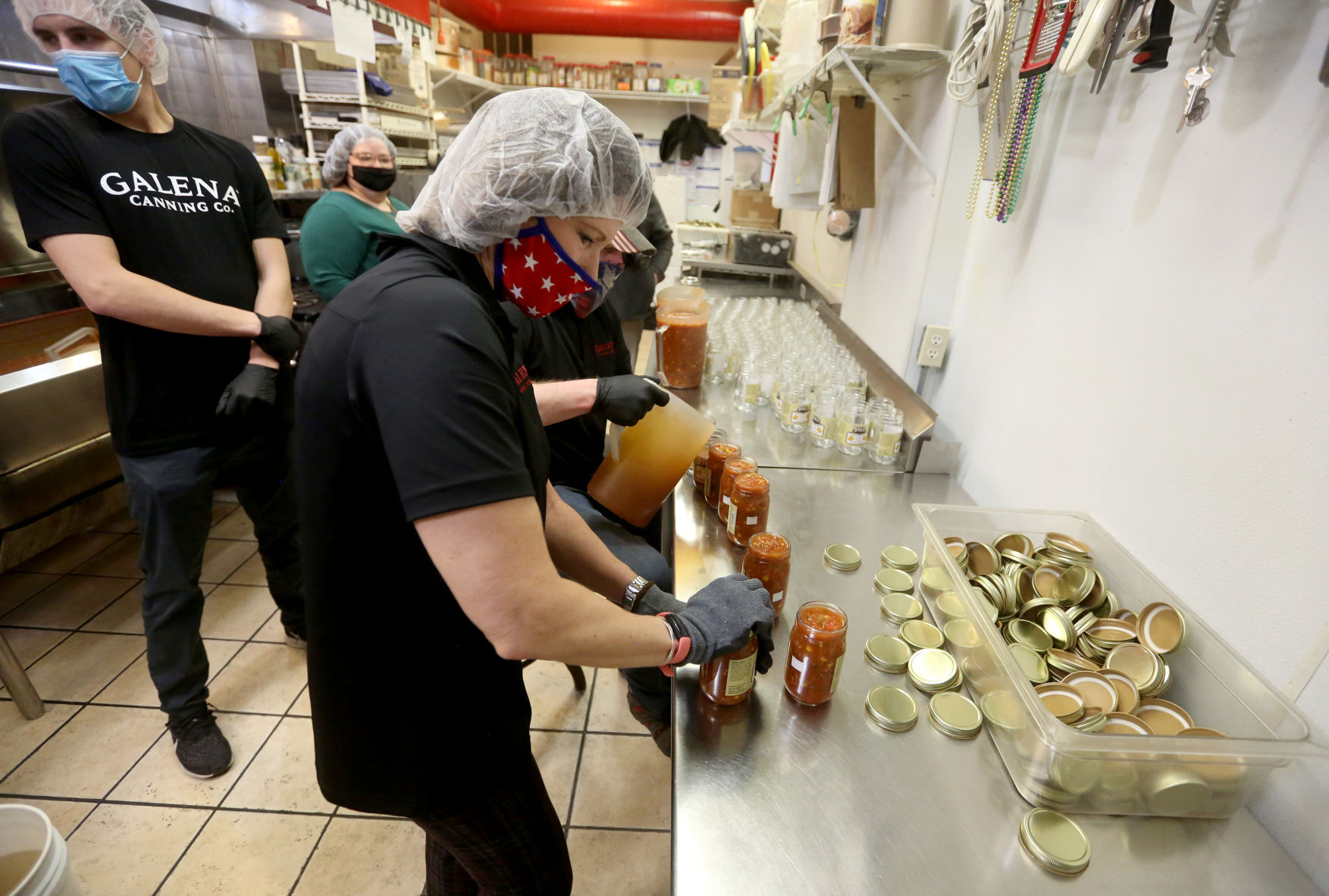 U.S. Rep. Cheri Bustos, D-Ill., puts lids on jars of roasted corn salsa at Galena Canning Co. in Galena, Ill., on Monday. Bustos also promoted federal legislation to help businesses’ succession planning. PHOTO CREDIT: JESSICA REILLY