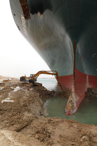 REMOVES REFERENCE TO BACKHOE - A work crew using excavating equipment tries to dig out the Ever Given, a Panama-flagged cargo ship, that is wedged across the Suez Canal and blocking traffic in the vital waterway. An operation is underway to try to work free the ship, which further imperiled global shipping Thursday as at least 150 other vessels needing to pass through the crucial waterway idled waiting for the obstruction to clear. (Suez Canal Authority via AP) PHOTO CREDIT: HOGP