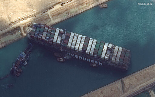 This satellite image from Maxar Technologies shows the cargo ship MV Ever Given stuck in the Suez Canal near Suez, Egypt, Friday, March 26, 2021. A maritime traffic jam grew to more than 200 vessels Friday outside the Suez Canal and some vessels began changing course as dredgers worked frantically to free a giant container ship that is stuck sideways in the waterway and disrupting global shipping. (©Maxar Technologies via AP) PHOTO CREDIT: ©Maxar Technologies