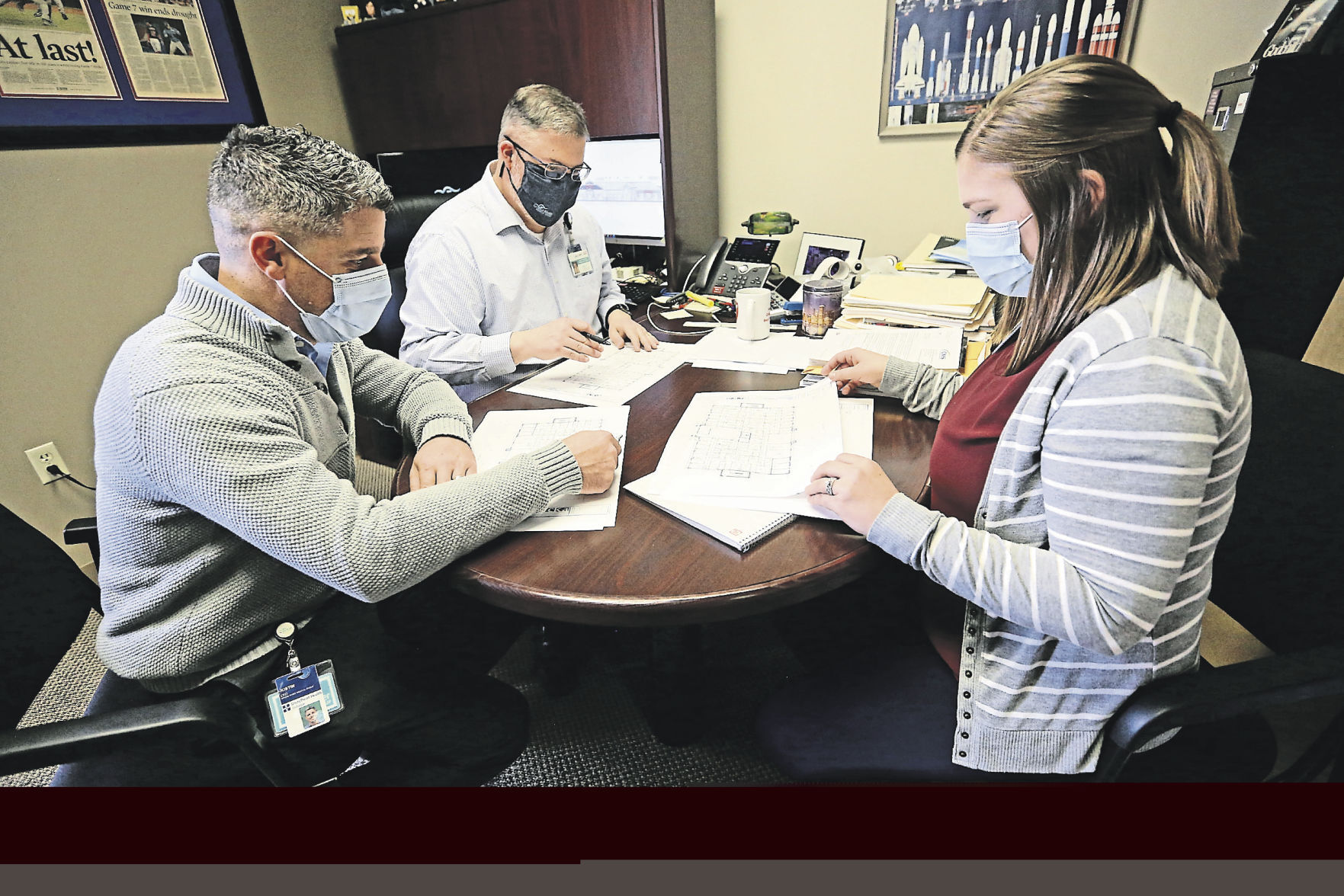 Justin Hafner (from left), CEO of Grand River Medical Group, Joel Gehling, CFO, and Kelly Goldsmith, executive assistant, go over paperwork at the facility in Dubuque. PHOTO CREDIT: Jessica Reilly