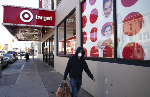 FILE - In this April 6, 2020 file photo, a customer wearing a mask carries his purchases as he leaves a Target store during the coronavirus pandemic, in the Brooklyn borough of New York. Target says it will spend a a total of more than $2 billion at Black-owned businesses by 2025 as part of its effort to advance racial equity. As part of its program, the Minneapolis-based discounter will add products from more than 500 Black-owned businesses across all types of merchandising areas. (AP Photo/Mark Lennihan, File) PHOTO CREDIT: Mark Lennihan