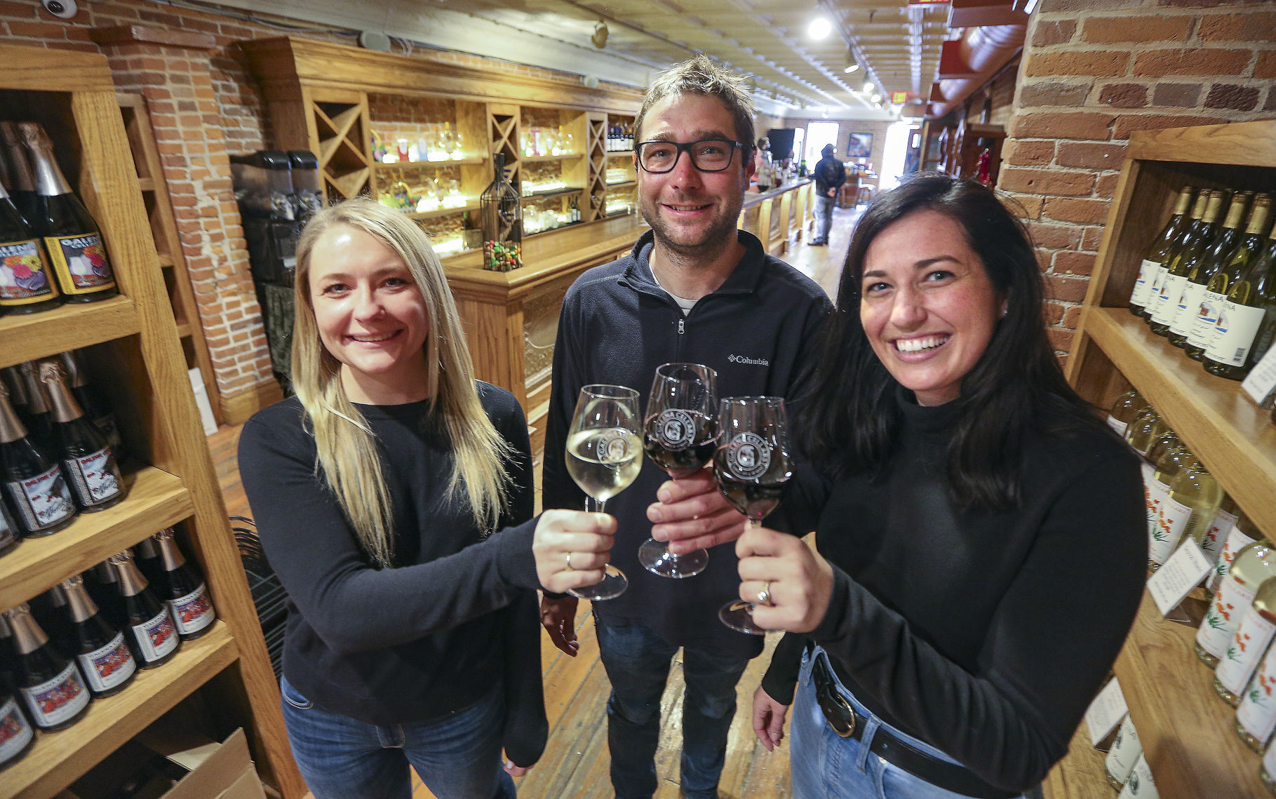 Galena Cellars Winery and Vineyard recently relocated to 111 N. Main St. in Galena, Ill. Pictured are members of the ownership family, Britt White (left) along with her brother, Eric White, and his wife, Oniqueh Giles-White.    PHOTO CREDIT: Dave Kettering