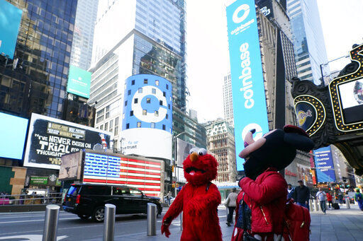 Costumed characters pass the Nasdaq MarketSite during the Coinbase IPO, in New York