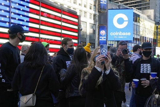 Coinbase employees gather Wednesday outside the Nasdaq MarketSite during the company’s IPO, in New York’s Times Square. PHOTO CREDIT: Richard Drew