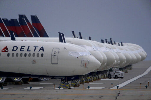 FILE - In this May 14, 2020 file photo, several dozen mothballed Delta Air Lines jets are parked on a closed runway at Kansas City International Airport in Kansas City, Mo. Delta Air Lines says it lost $1.2 billion in the first quarter, but the airline thinks it can by profitable by late summer unless there