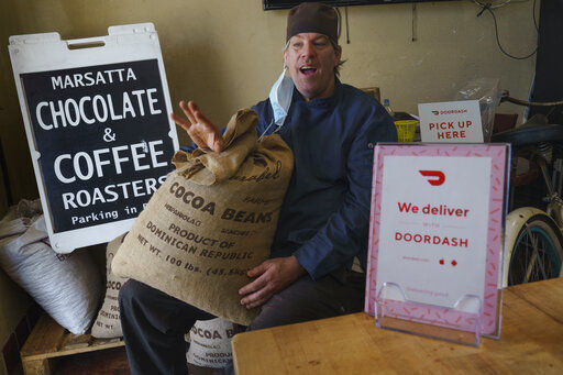 Jeffray Gardner, the owner of Marsatta Chocolate poses with a bag of cocoa beans at his company