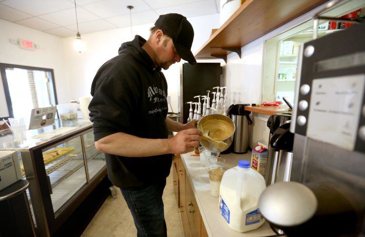 Joe McComish, co-owner of Lucky Cow Coffee & Gelato in Darlington, Wis., prepares a drink order in March 2020.  PHOTO CREDIT: JESSICA REILLY