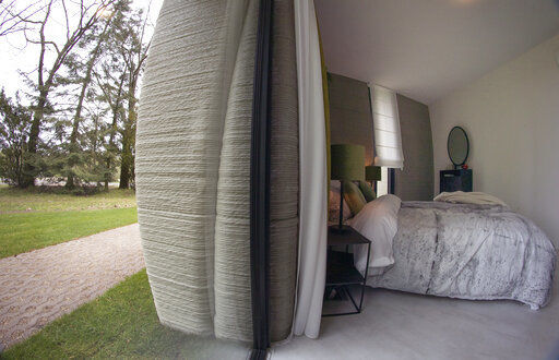 View of the bedroom showing the printer layers in the walls of the 3D-printed 94-square meters (1,011-square feet) two-bedroom bungalow resembling a boulder with windows in Eindhoven, Netherlands, Friday, April 30, 2021. The fluid, curving lines of its gray walls look natural. But they are actually at the cutting edge of housing construction in the Netherlands and around the world. They were 3D printed at a nearby factory. (AP Photo/Peter Dejong) PHOTO CREDIT: Peter Dejong
