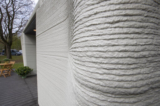 Exterior view showing the printer layers of the 3D-printed 94-square meters (1,011-square feet) two-bedroom bungalow resembling a boulder with windows in Eindhoven, Netherlands, Friday, April 30, 2021. The fluid, curving lines of its gray walls look natural. But they are actually at the cutting edge of housing construction in the Netherlands and around the world. They were 3D printed at a nearby factory. (AP Photo/Peter Dejong) PHOTO CREDIT: Peter Dejong