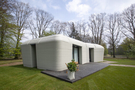 Exterior view showing the printer layers in the walls of the 3D-printed 94-square meters (1,011-square feet) two-bedroom bungalow resembling a boulder with windows in Eindhoven, Netherlands, Friday, April 30, 2021. The fluid, curving lines of its gray walls look natural. But they are actually at the cutting edge of housing construction in the Netherlands and around the world. They were 3D printed at a nearby factory. (AP Photo/Peter Dejong) PHOTO CREDIT: Peter Dejong