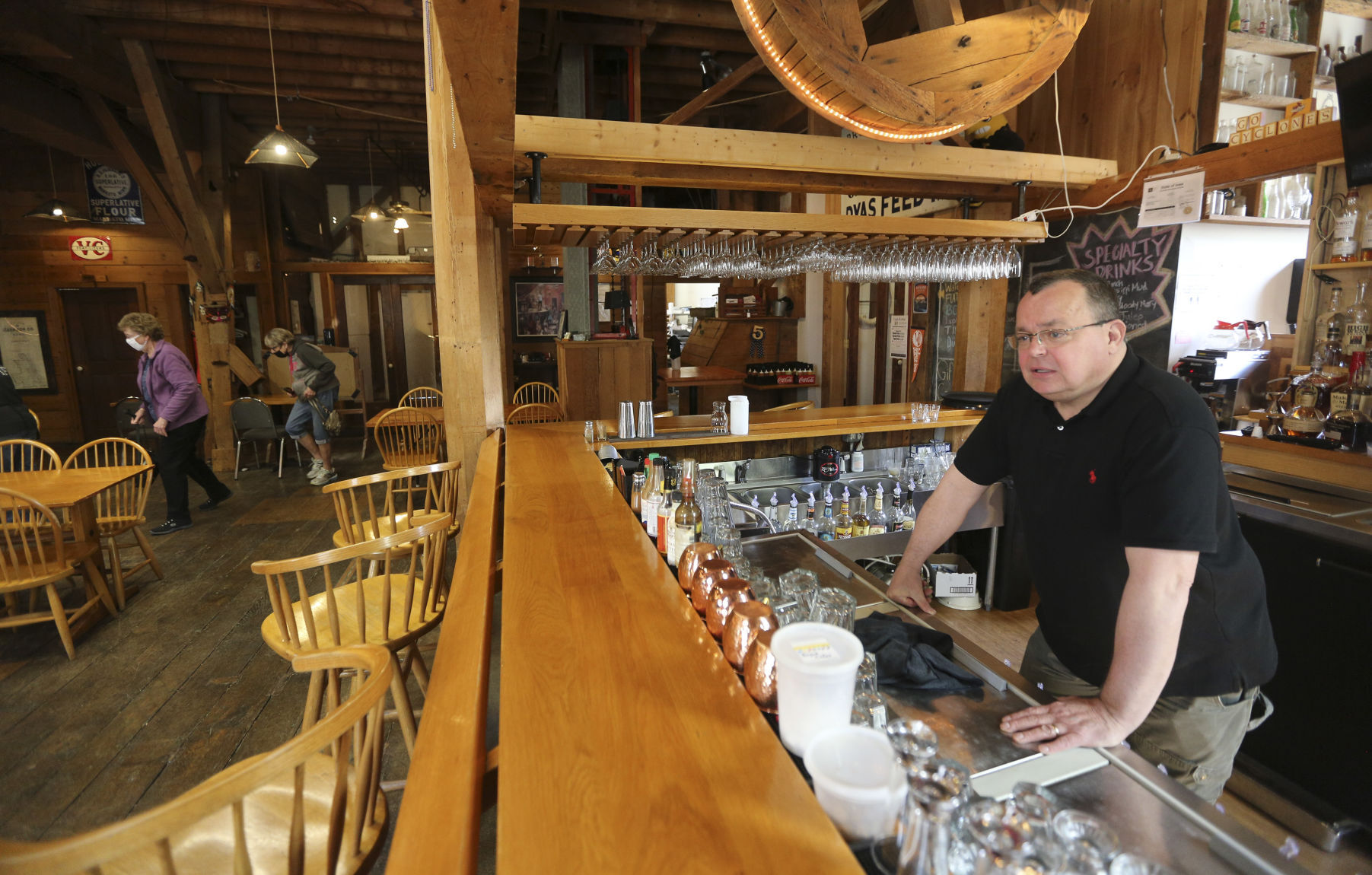 Mark Herman, owner and manager of Flatted Fifth Blues & BBQ in Bellevue, Iowa, tends bar during lunch hour Thursday. Herman has seen “a gradual increase” in customers. PHOTO CREDIT: Dave Kettering