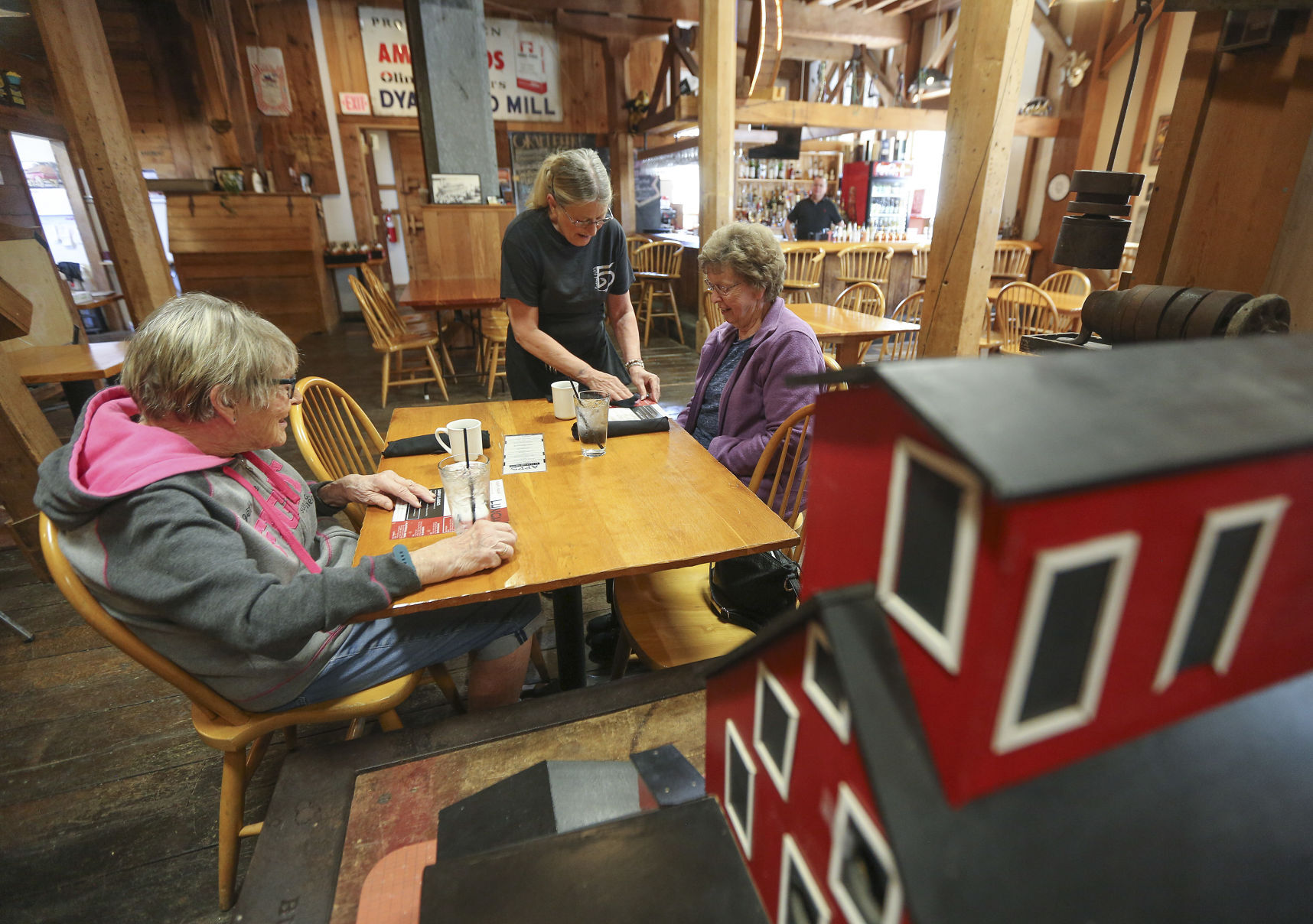Lou Ann Meier, a waitress at Flatted Fifth Blues & BBQ in Bellevue, Iowa, serves customers Janet Koehler (left) and Joyce Till, both of Andrew, Iowa, at the restaurant on Thursday. PHOTO CREDIT: Dave Kettering