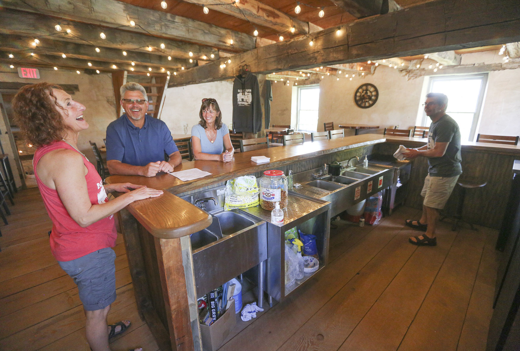 The owners of Gehlen House Inn and Barn, Kari Vize (left) and her husband, Don (far right), chat Sunday with customers Rhett and Keller Coatney, of Sabula, Iowa. The historic establishment recently reopened after some renovations. PHOTO CREDIT: Dave Kettering