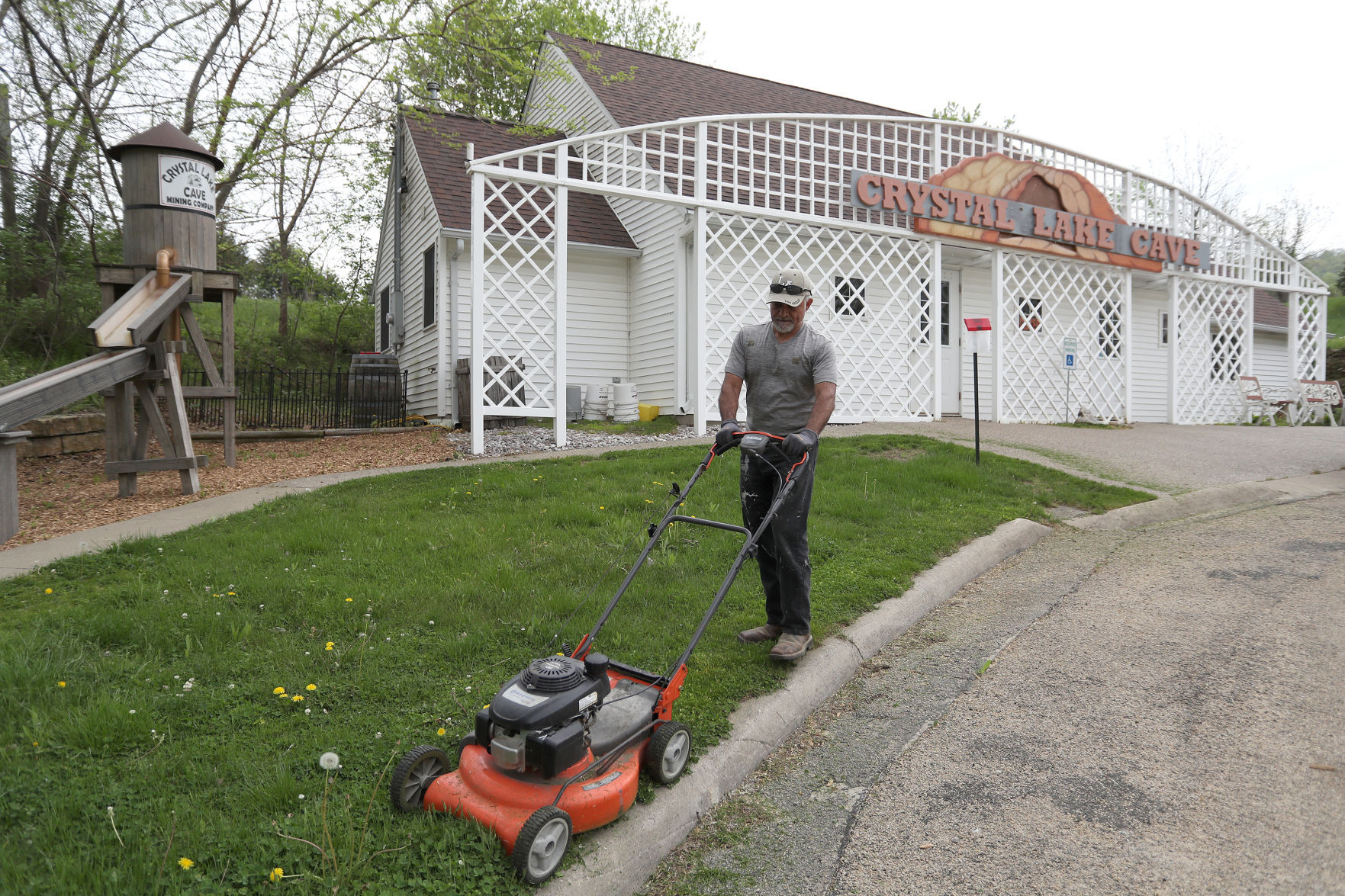Manager Pablo Ramirez mows the grass at Crystal Lake Cave south of Dubuque on Monday. The business is set to reopen to visitors on weekends starting Saturday, May 8, and every day as of Memorial Day weekend.    PHOTO CREDIT: Stephen Gassman
