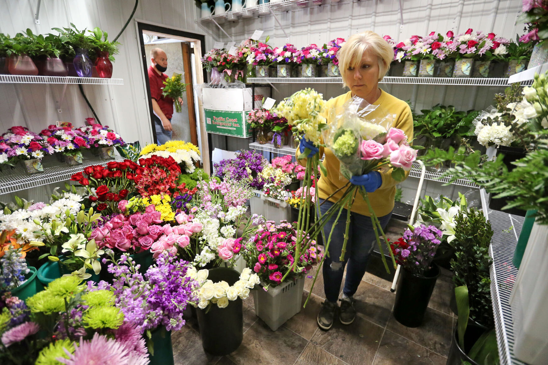 Julie Gross gathers flowers while working on a flower arrangement at Butt
