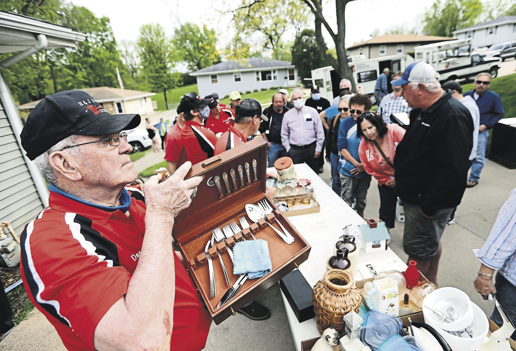 Doc Johnston (left), co-owner of H&J Auction Service, shows off an item for bidding during an estate auction. PHOTO CREDIT: Dave Kettering