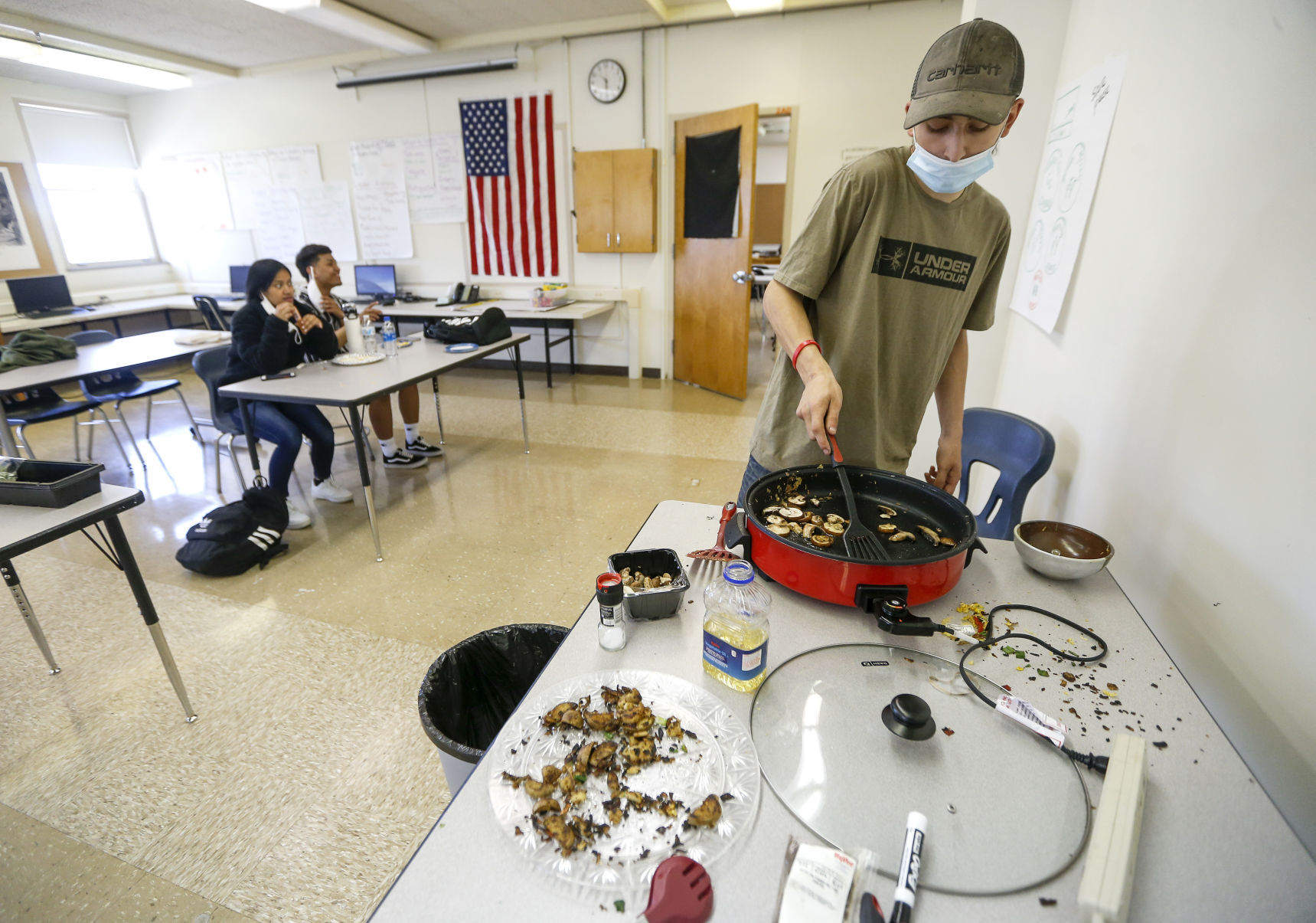 Alternative Learning Center student Dylan Galle, 17, cooks food Friday using the microgreens grown in class. PHOTO CREDIT: Dave Kettering