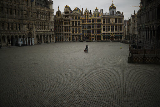 FILE - In this Friday, March 20, 2020 file photo, a man riding a bicycle takes photographs in a the Grand Place in Brussels. The European Union on Wednesday, May 19, 2021 took a step toward relaxing tourism travel for visitors from outside the bloc, with EU ambassadors agreeing on measures to allow fully vaccinated visitors in. They also agreed on easing the criteria for nations to be considered a safe country, from which all tourists can travel. Up to now, that list included only seven nations. (AP Photo/Francisco Seco, File) PHOTO CREDIT: Francisco Seco