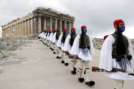 FILE - In this Thursday, March 25, 2021 file photo, members of the Presidential Guard walk in front of the Parthenon temple atop of Acropolis Hill in Athens. The European Union on Wednesday, May 19, 2021 took a step toward relaxing tourism travel for visitors from outside the bloc, with EU ambassadors agreeing on measures to allow fully vaccinated visitors in. They also agreed on easing the criteria for nations to be considered a safe country, from which all tourists can travel. Up to now, that list included only seven nations. (AP Photo/Petros Giannakouris, Pool, File) PHOTO CREDIT: Petros Giannakouris