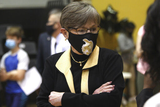 In this Monday, May 17, 2021, photo, Kansas Gov. Laura Kelly tours a COVID-19 vaccination clinic for students aged 12 through 15 set up in a gym at Topeka High School in Topeka, Kan. The Democratic governor is under increasing pressure to end an extra $300 a week in benefits for unemployed workers, with critics of the aid arguing that businesses are having problems hiring enough workers because of it. (AP Photo/John Hanna) PHOTO CREDIT: John Hanna