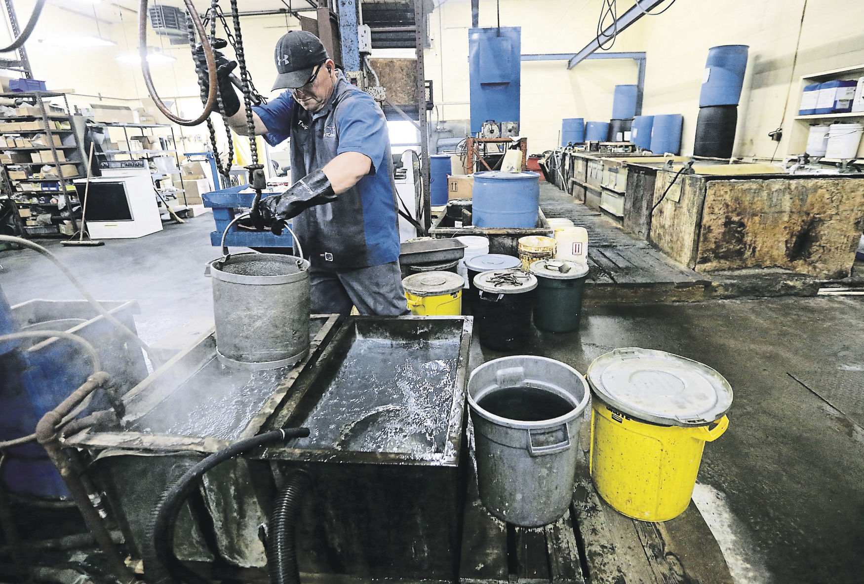 Troy Mulholland works to barrel zinc clear finish items at Key City Plating in Dubuque. The business started in 1971. Its focus is working on smaller quantities of metal parts that need refinishing. Rich Conlon assumed ownership of the business around 2008. PHOTO CREDIT: JESSICA REILLY