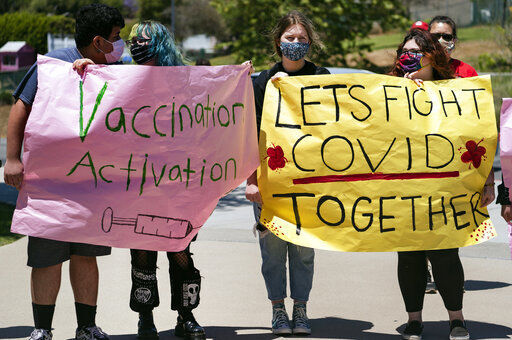 San Pedro High School students hold vaccination signs at a school-based COVID-19 vaccination event for students 12 and older in San Pedro, Calif., Monday, May 24, 2021. Schools are turning to mascots, prizes and contests to entice youth ages 12 and up to get vaccinated against the coronavirus before summer break. (AP Photo/Damian Dovarganes) PHOTO CREDIT: Damian Dovarganes