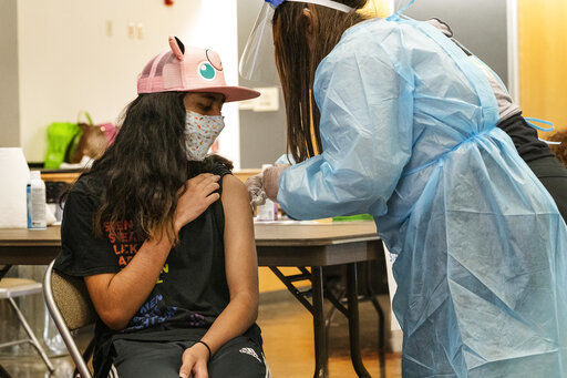 High school freshman Jeff Eseroma, 14, is vaccinated at a school-based COVID-19 vaccination clinic for students 12 and older in San Pedro, Calif., Monday, May 24, 2021. Schools are turning to mascots, prizes and contests to entice youth ages 12 and up to get vaccinated against the coronavirus before summer break. (AP Photo/Damian Dovarganes) PHOTO CREDIT: Damian Dovarganes