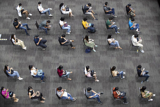 Airline employees sit after receiving the Sinovac COVID-19 vaccine to be sure of no side effects at the Siam Paragon shopping mall in Bangkok, Thailand, Tuesday, May 25, 2021. (AP Photo/Sakchai Lalit) PHOTO CREDIT: Sakchai Lalit
