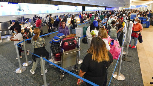 Travelers check in at a ticket counter at Orlando International Airport before the Memorial Day weekend Friday, May 28, 2021, in Orlando, Fla. (AP Photo/John Raoux) PHOTO CREDIT: John Raoux