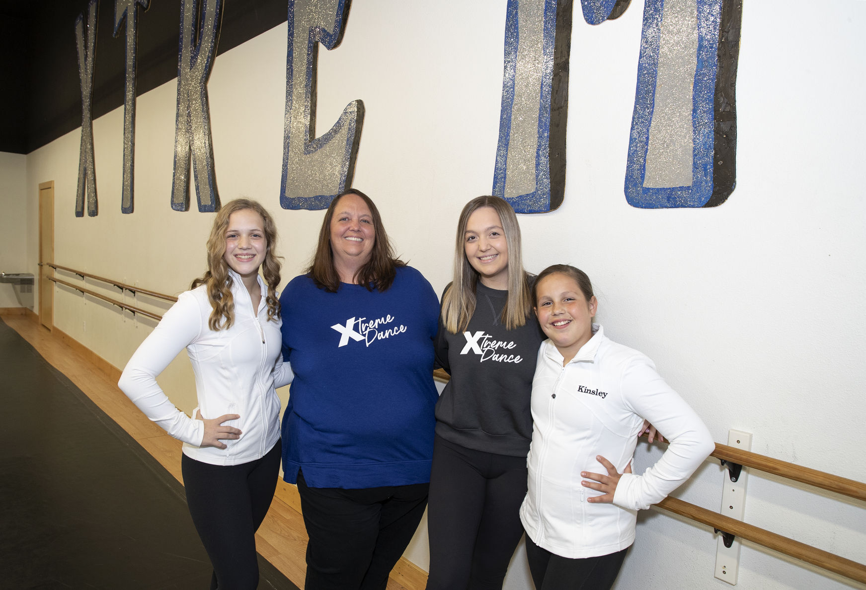 Tracy Goedken (center in blue) and her 3 daughters (from left), Aubrey, Kylie, and Kinsley, in one of the dance studios at Xtreme Dance on Cedar Cross Road in Dubuque on Friday.    PHOTO CREDIT: Stephen Gassman