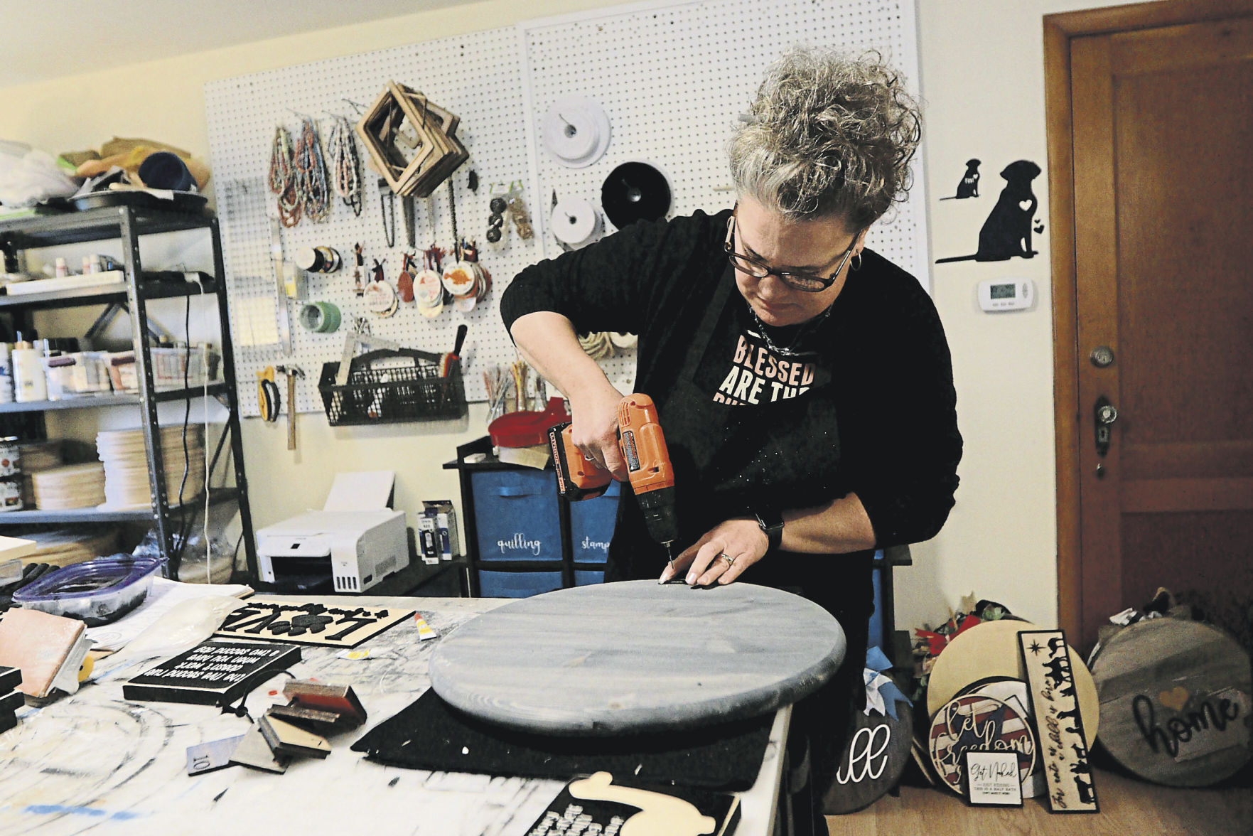 Owner Amy O’Rourke puts together wooden signs at Bead and Board. The Dubuque business offers home decorations and jewelry. PHOTO CREDIT: Katie Goodale