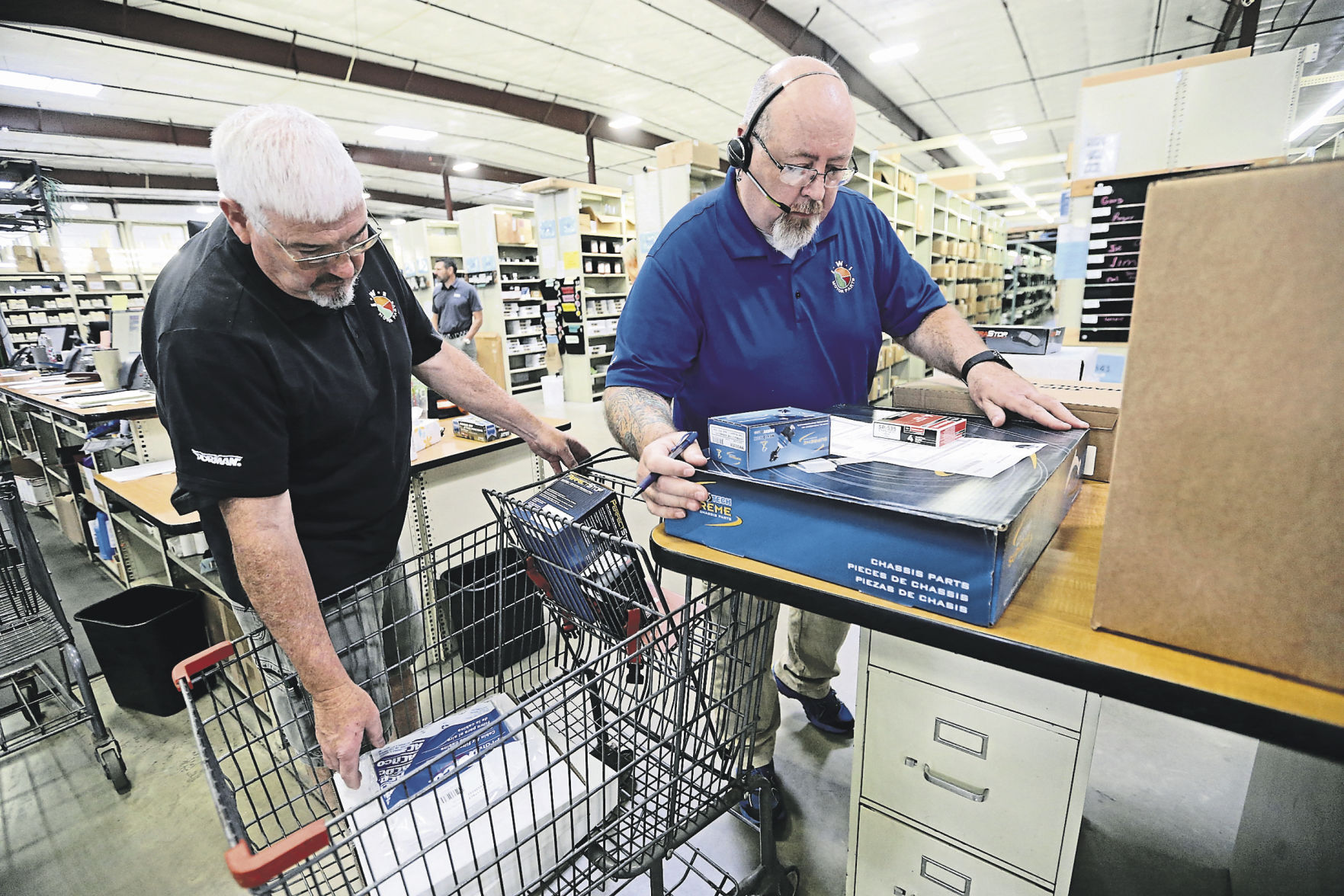 Gary McFadden (left) and Tom Robinett prepare an order at IWI Motor Parts. The automotive part wholesale distribution company, based in Dubuque, has 14 locations and more than 250 employees. IWI was started by Mike Faley in 1962.    PHOTO CREDIT: JESSICA REILLY