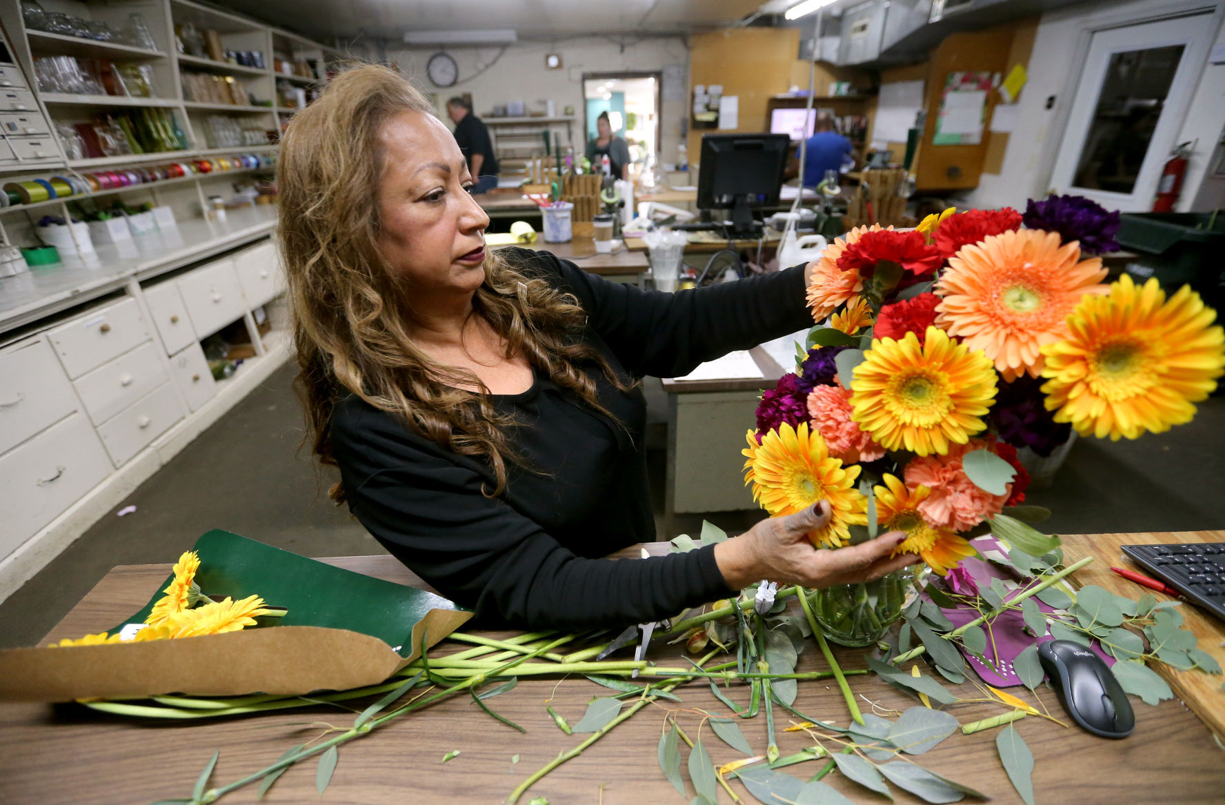 Gloria Gaber works on a flower arrangement at White Florist in Dubuque on Monday.    PHOTO CREDIT: JESSICA REILLY