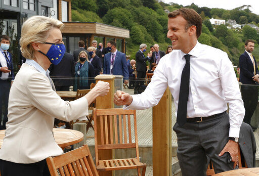 European Commission President Ursula von der Leyen, left, greets French President Emmanuel Macron with a fist bump during an EU coordination meeting prior to the G7 meeting at the Carbis Bay Hotel in Carbis Bay, St. Ives, Cornwall, England, Friday, June 11, 2021. Leaders of the G7 begin their first of three days of meetings on Friday, in which they will discuss COVID-19, climate, foreign policy and the economy. (Phil Noble, Pool via AP) PHOTO CREDIT: Phil Noble