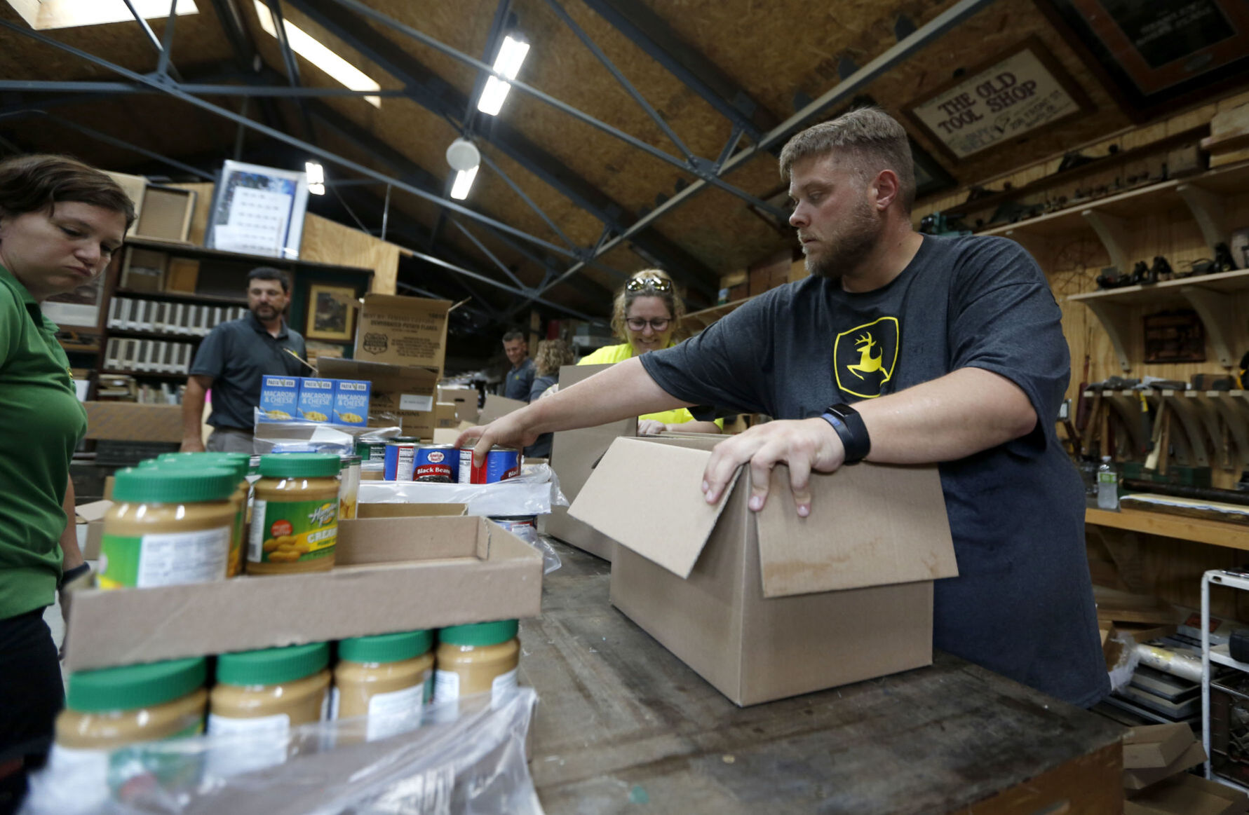 David Yeager, a volunteer with John Deere, packages food pantry boxes during an event at Convivium Urban Farmstead on Thursday, June 17, 2021. PHOTO CREDIT: Katie Goodale