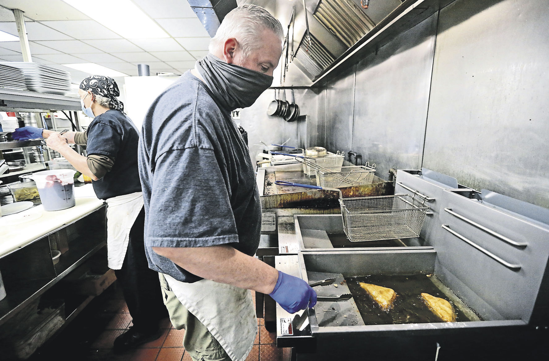 Tammy Hammel (left) and Michael Pratte prepare practice meals for Bennigan’s On the Fly at Holiday Inn Dubuque in February. The virtual kitchen has opened.    PHOTO CREDIT: JESSICA REILLY