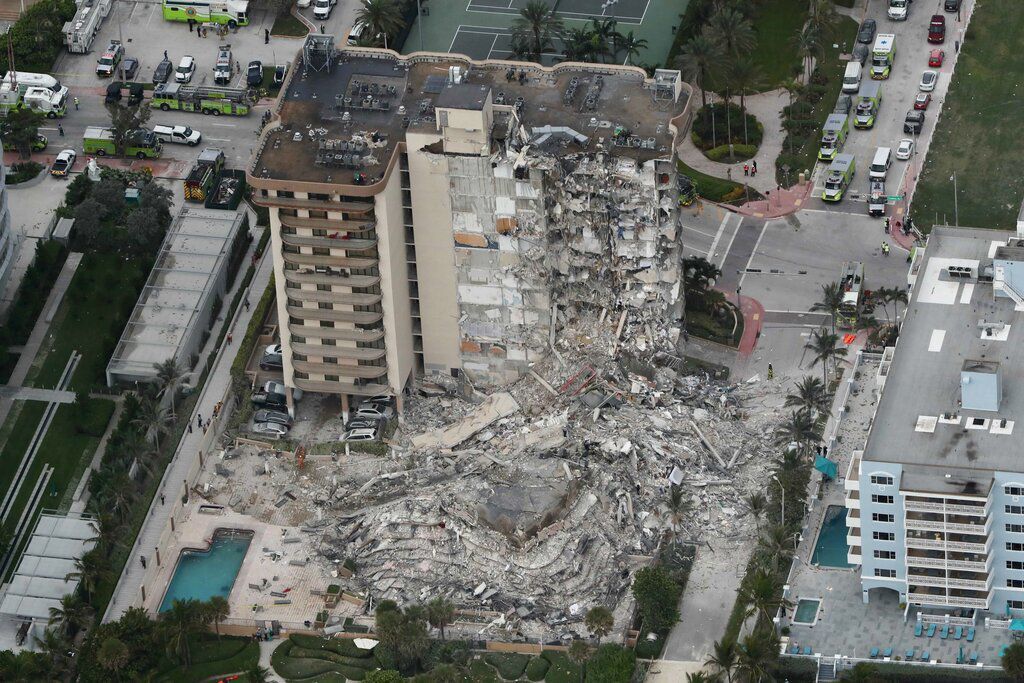 This aerial photo shows part of the 12-story oceanfront Champlain Towers South Condo that collapsed early today in Surfside, Fla. Scores of rescuers pulled survivors from the debris as a cloud of dust floated through the neighborhood. At least one person was killed. PHOTO CREDIT: Amy Beth Bennett/South Florida Sun-Sentinel via AP