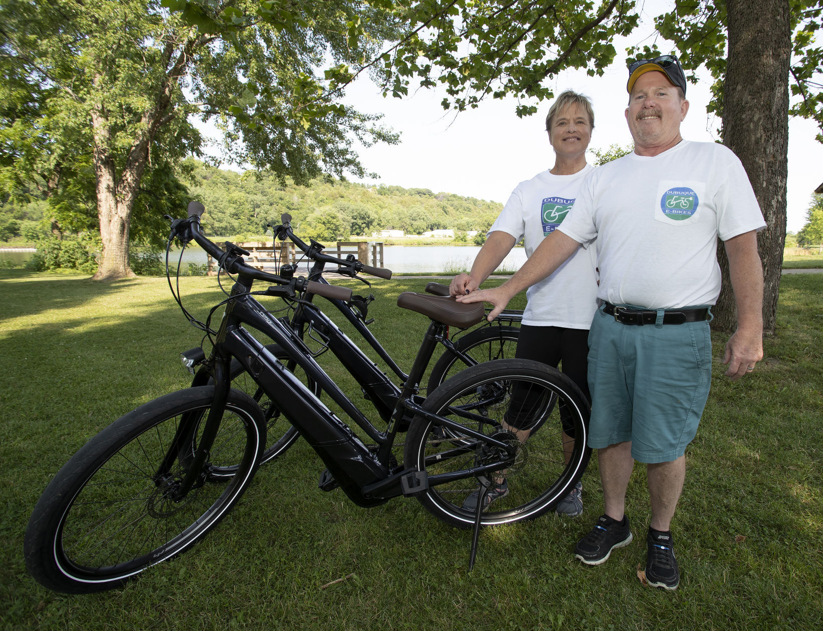 Sherri and John Driscoll display two of their pedal-assist electric bikes on Friday at Heritage Trail. The bikes are available for rent from their company, Dubuque E-Bikes.    PHOTO CREDIT: Stephen Gassman
