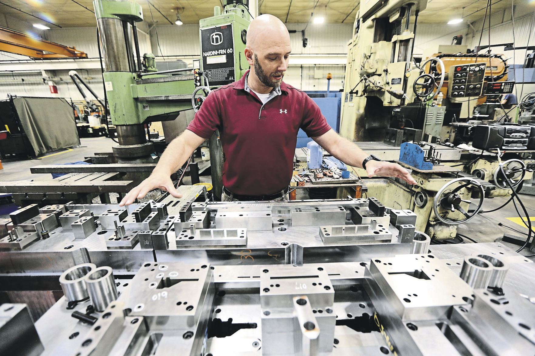 Uelner Precision Tools & Dies Continuous Improvement Manager Brad Kueter shows the detail work that goes into making a die cast.    PHOTO CREDIT: Dave Kettering