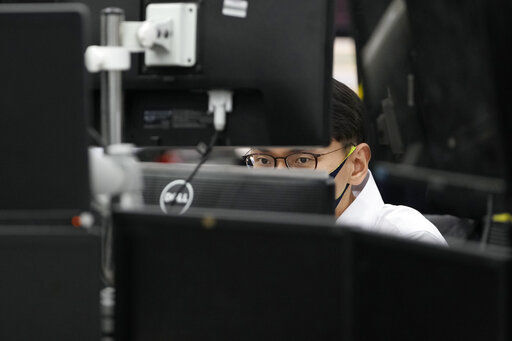 A currency trader watches computer monitors at the foreign exchange dealing room in Seoul, South Korea. Stocks were wobbling between small gains and losses in early trading today ahead of a wave of earnings reports from big U.S. companies coming out this week. PHOTO CREDIT: Lee Jin-man