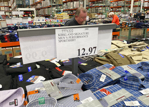 A sign displays the price for shirts as a shopper peruses the offerings at a Costco warehouse in Lone Tree, Colo. American consumers faced a third straight monthly surge in prices in June, the latest evidence that a rapid reopening of the economy is fueling pent-up spending for goods and services that in many cases remain in short supply. PHOTO CREDIT: David Zalubowski